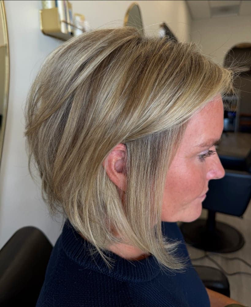 Stacked, softly layered bob with fine dimensional blonde highlights, side view — hair by Alchemy Loft