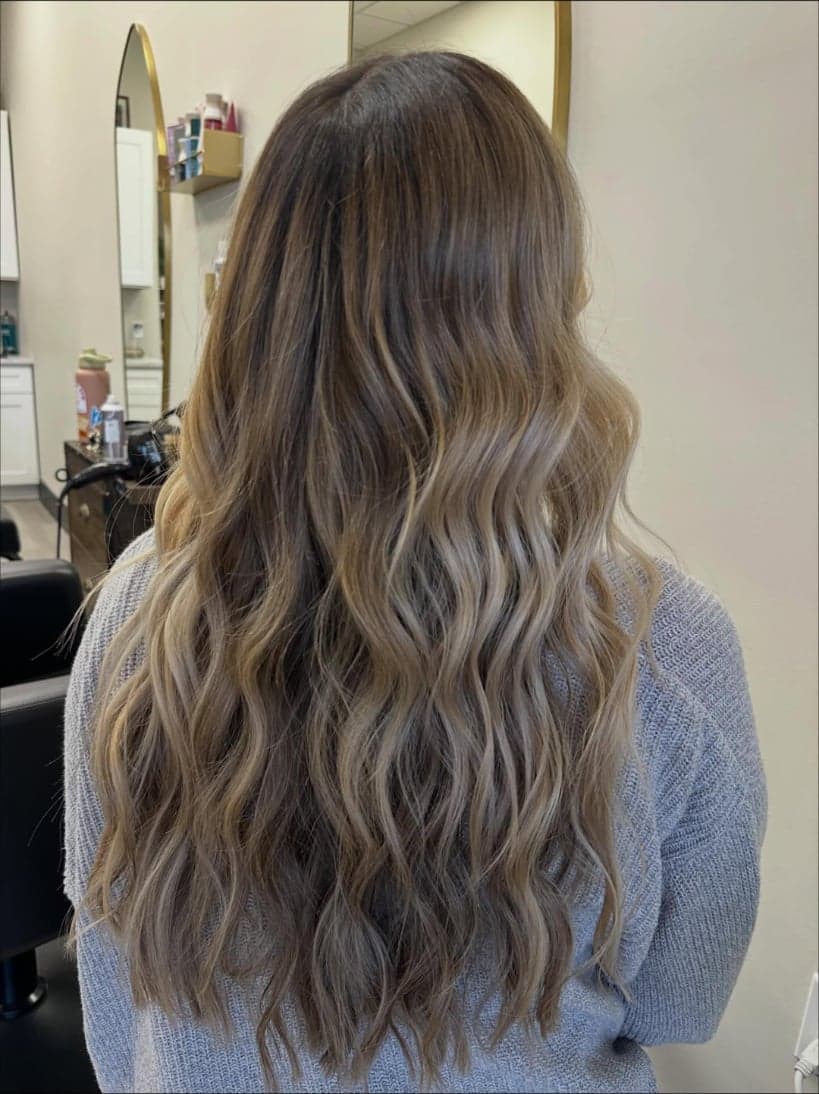 Long beige-blonde waves melting from a deep root shadow, back view — hair by Alchemy Loft