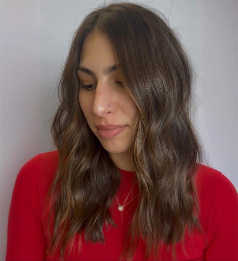 Deep brunette with fine, warm caramel ribbons of dimension in loose waves — hair by Alchemy Loft