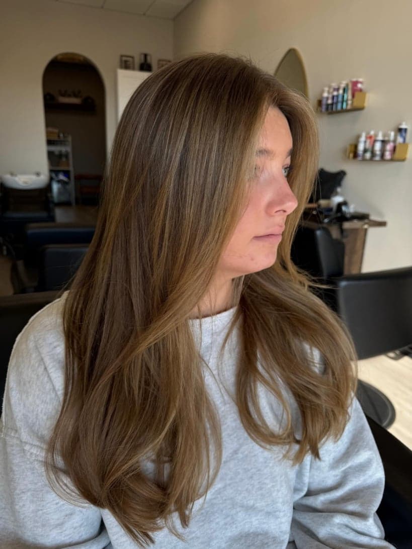 Former platinum taken to a warm, glossy golden brunette, with long soft layers — hair by Alchemy Loft
