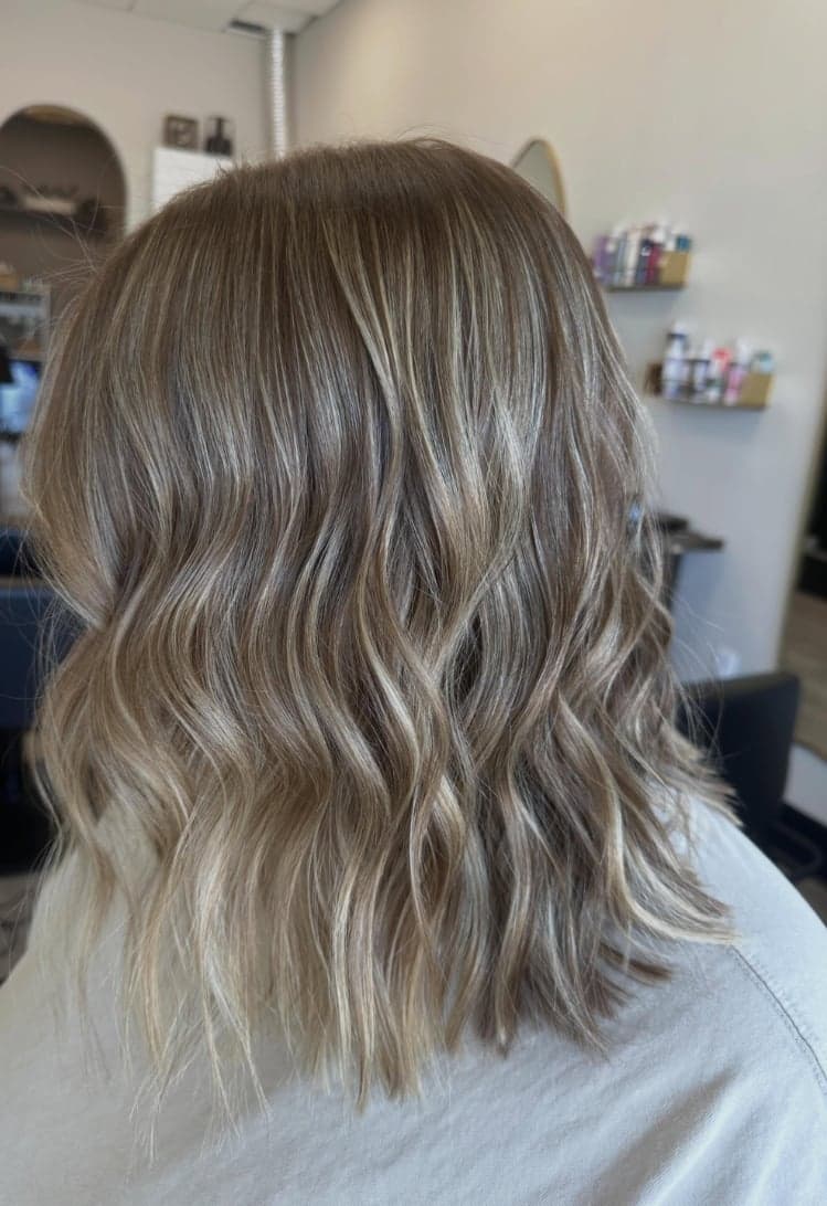 Shoulder-length lob with soft blonde balayage and textured waves, back view — hair by Alchemy Loft
