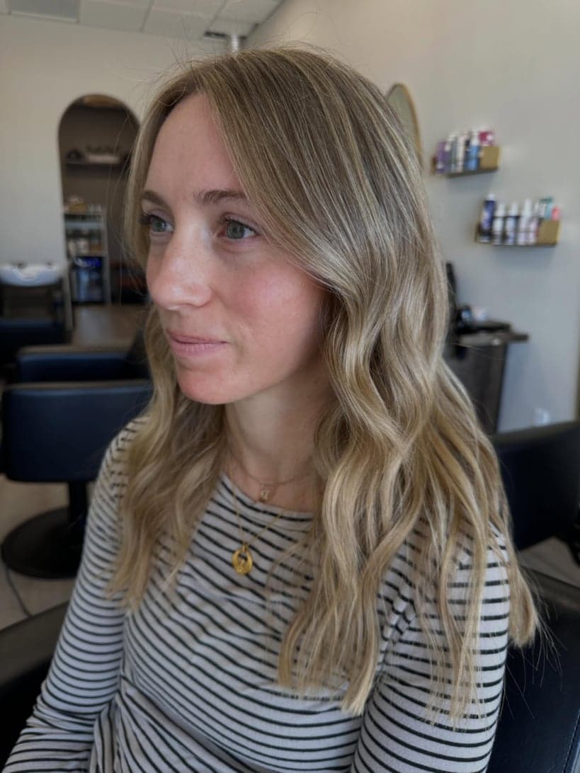 Honey-beige blonde with a soft root shadow and long waves, front view — hair by Alchemy Loft