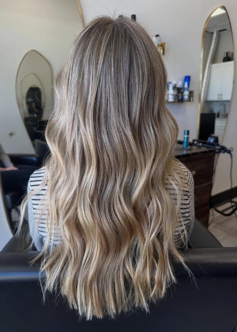 Long lived-in blonde balayage brightening toward the ends, back view — hair by Alchemy Loft