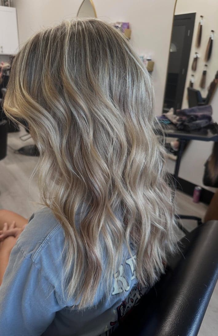 Soft root shadow melting into bright, blended blonde waves, side view — hair by Alchemy Loft